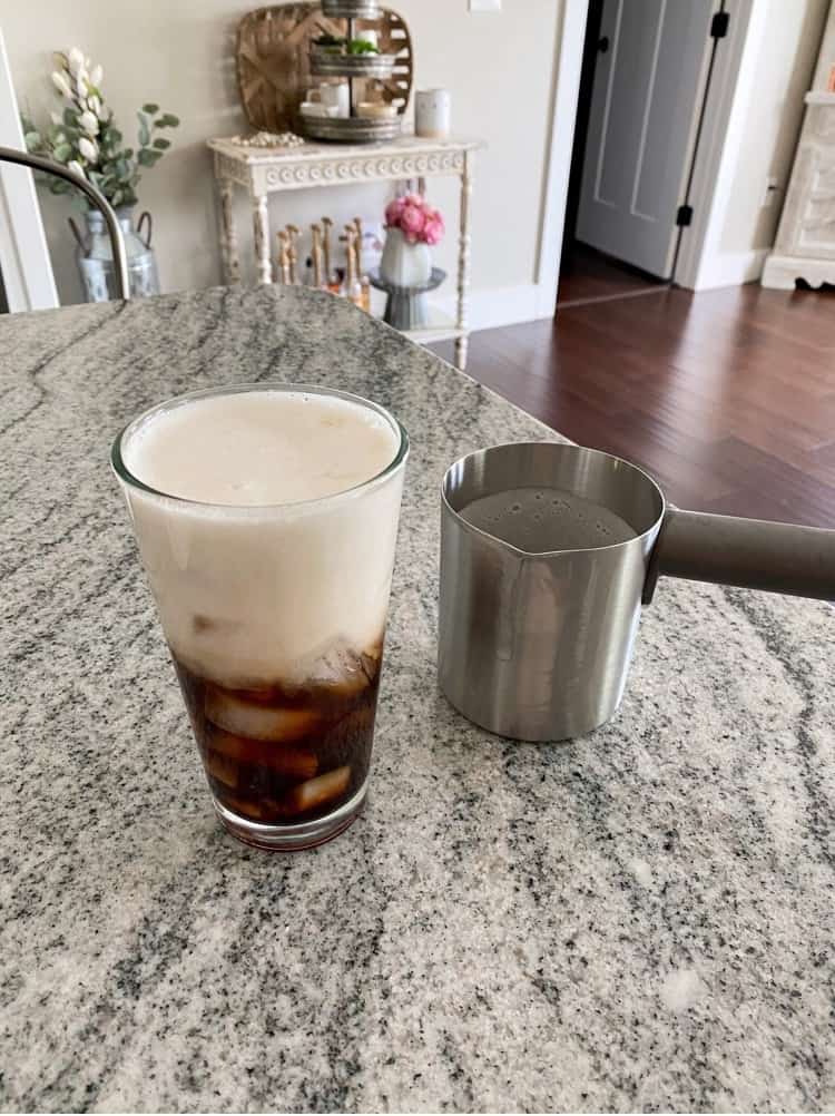 Pouring frothed milk into coffee