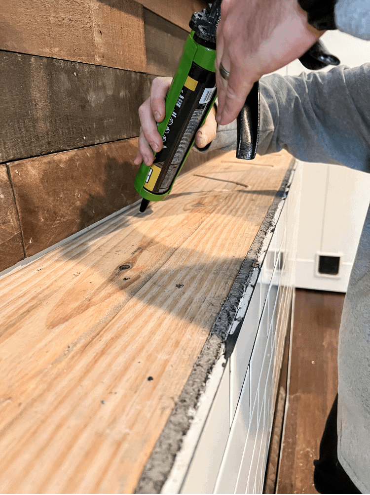 Adding wood glue on top of fireplace for mantel